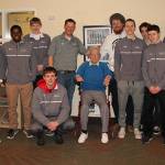 The VHS varsity basketball team, with coaches Sears and Sean Hoogen, gather around Schwartz at VCC.