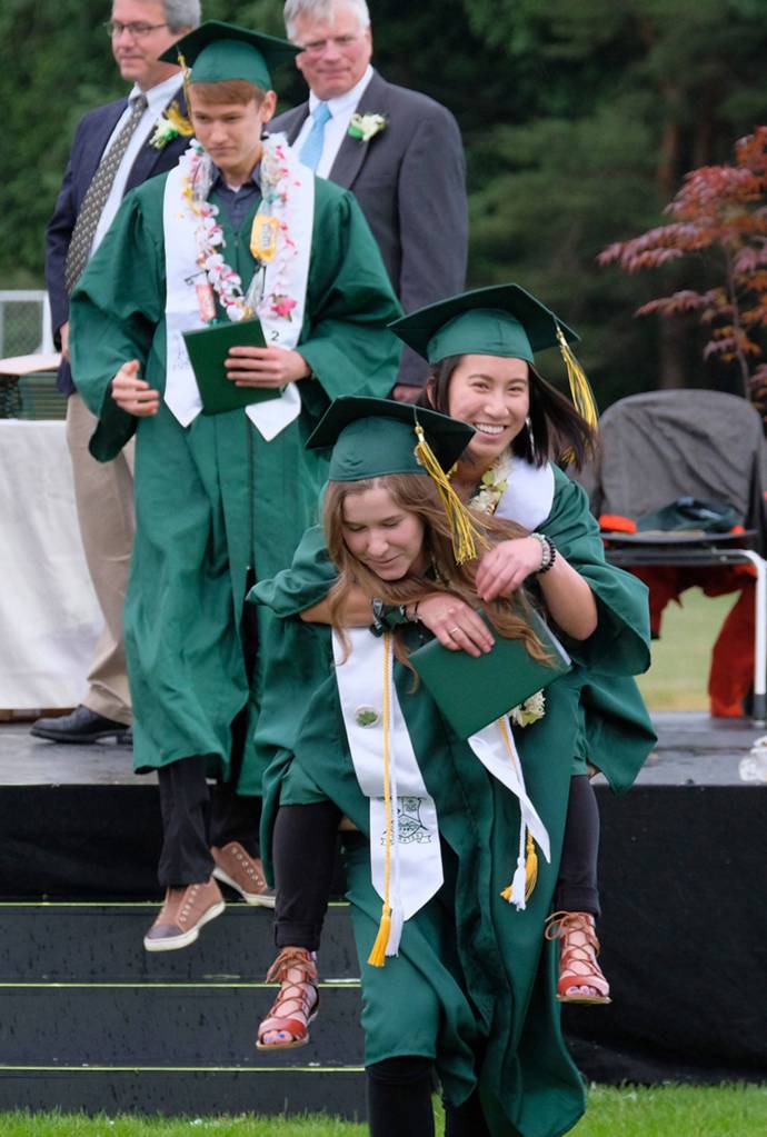 A Vashon high School senior gets a piggyback ride from a friend after receiving her diploma Saturday evening. (Kent Phelan photo)