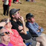 Donning special eclipse glasses, a group of islanders sits in the grass at Sunrise Ridge to watch Monday&rsquo;s eclipse. (Anneli Fogt/Staff Photo)