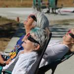 A group of women relaxes at Sunrise Ridges as the moon makes its way in front of the sun Monday morning. The eclipse was the country&rsquo;s first since 1979. (Anneli Fogt/Staff Photo)