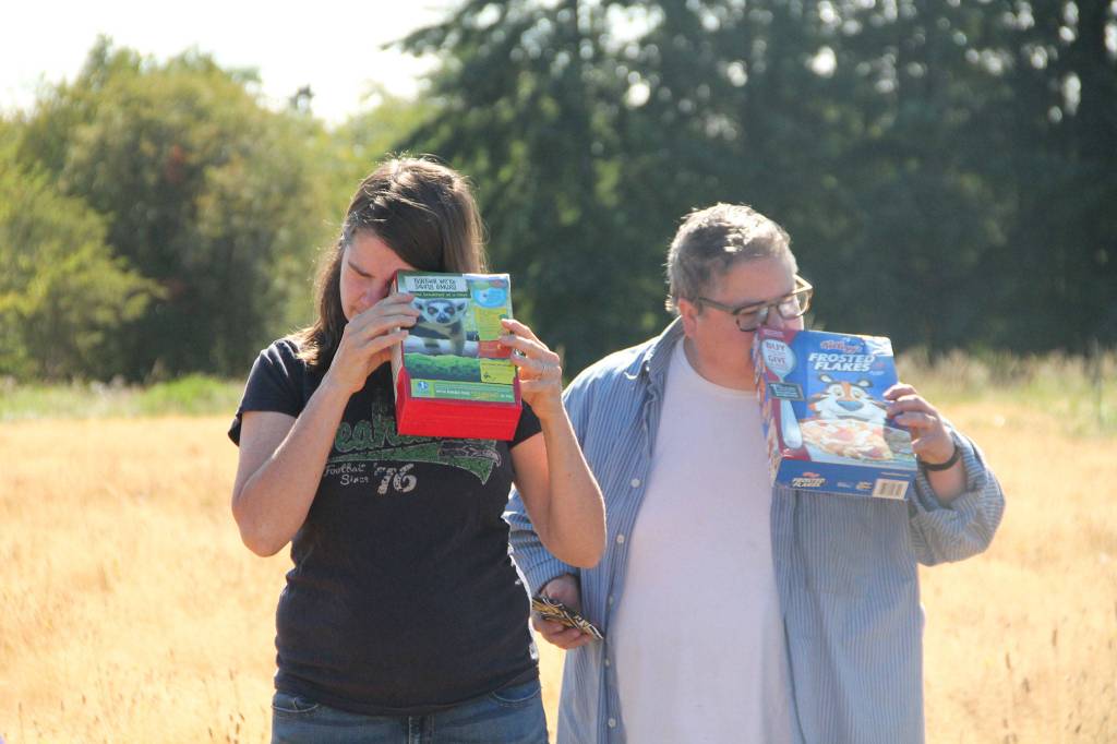 While some donned eclipse glasses, others transformed cardboard cereal boxes into pinhole viewers to view the eclipse safely. (Anneli Fogt/Staff Photo)