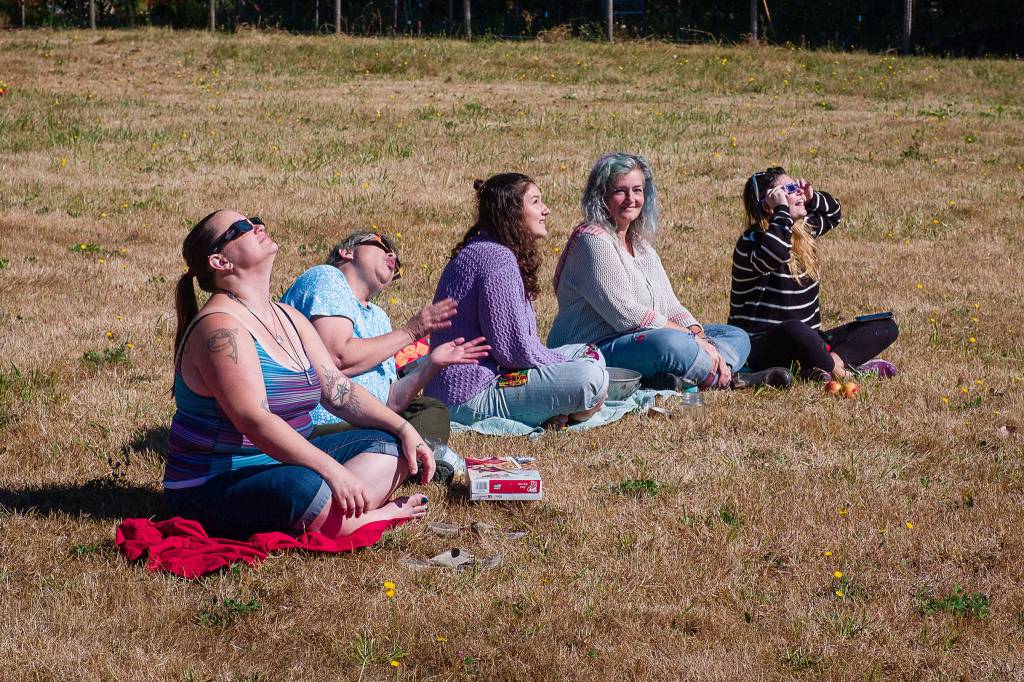 A group of women smiles and laughs as the eclipse occurs Monday morning. (Kent Phelan Photo)