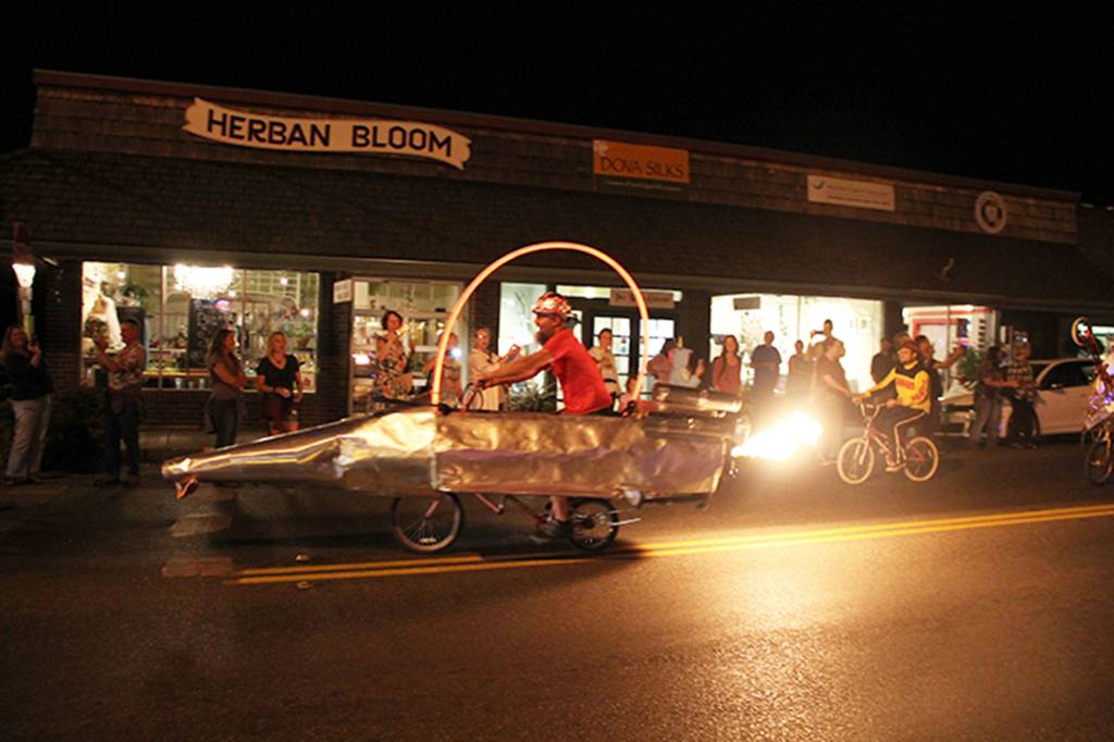 A man on a &ldquo;bike&rdquo; that spits flames out the back cruises up Vashon Highway. (Susan Riemer/Staff Photo)
