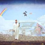 Artist Tom Teitge stands in front of his 1978 mural during a re-touching break last week. (Maggie Smith Photo)