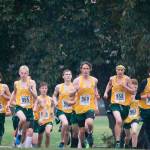 Left to right: Simon Clark (#955), Garrett Mueller (#965), Ursa Medeiros, Hunter Justis, Gianno Waller (#969), Cole Parks (#958), Jackson Mallory (#963) and Sean Robertson (#956) take off from the starting line and charge uphill at the Nisqually League meet last Thursday. (Matthew Boyle Photo)