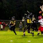 Vashon High School senior Cody Whitman (far right, #66) jumps up to block a point-after kick from Port Townsend&rsquo;s Nico Winegar. Vashon&rsquo;s Jonathan Quintans (#84), Steven Rice (#82) and Will Hennessey (behind Rice) assist. The Redhawks had just scored to tie with the Pirates 21-21 in the first overtime period and had they made the kick, they would have won the game. After a second overtime period, Vashon won 27-21. (John Sage/FinchHaven Photo)