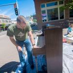Port Angeles Council member and downtown business owner Mike French works on a piano, which he started putting out downtown during sunny days last year, during a work party on Saturday. (Jesse Major/Peninsula Daily News)