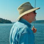 Islander Bruce Haulman observes county shoreline restoration work during a guided tour in Puget Sound last week (Paul Rowley/ Staff Photo).