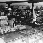 Coy Meredith sits at a counter inside the Burton Store likely in the 1920s. (Photo courtesy of the Vashon-Maury Island Heritage Museum)