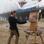 Steffon Moody, shown here painting in the rain at the Santa Monica Pier, will have his third annual solo show at The Hardware Store Restaurant Gallery (Courtesy Photo).