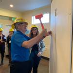 Vashon Community Care resident John Whitney hammers out a piece of wall in the facility to mark the start of construction on the memory care wing on Thursday, Oct. 24 (Kevin Opsahl/Staff Photo).
