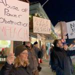 Zoe Rothchild, in the foreground, holds a sign stating the articles of impeachment against President Donald Trump as others demonstrate during a Nobodys Above the Law rally on Tuesday, Dec. 17 at Vashon Highway and Bank Road. The demonstration was held one day before the House of Representatives was expected to impeach the president (Kevin Opsahl/Staff Photo).