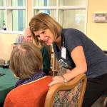 Wendy Kleppe, the new executive director of Vashon Community Care, greets a resident during a reception at the senior living community on Dec. 6. (Kevin Opsahl/Staff Photo)