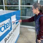 Island resident Pati Russell-Lamboau drops off her ballot at the King County Elections voter drop box at the library on Friday, Feb. 28. (Kevin Opsahl/Staff Photo)