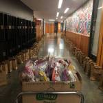 More than 400 grocery bags stuffed with three days worth of nutritious breakfasts and lunches for island youth enough to see them through Memorial Day  lined the hallways of Vashon High School prior to delivery on Thursday. The free meal delivery by the school district, led by Lisa Cyra, is one of many heroic efforts in our community in the midst of the coronavirus crisis (Louis Mangione Photo).