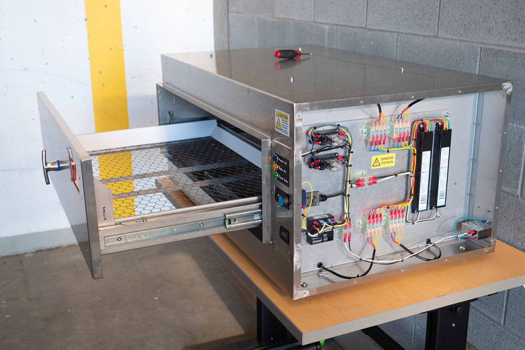 Building one decontamination box requires approximately 12 hours of shop labor. Pictured is a box with a side panel removed, showing some of the inner components of the device (Andy Freeberg Photo).