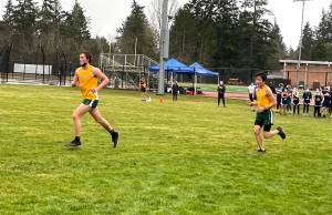Ben Larson (left) and Levi Blasingam (right) running through the muddy grass on their second loop of the cross-country course, which was modified to allow for social distancing.