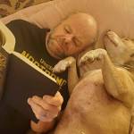 Phil Clapham, reading and dreaming, with a trusty friend by his side (Courtesy Photo).