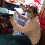 Teacher Laura Favela helps ECEAP pre-schoolers tidy up before they can go outside to play (Susan McCabe Photo).