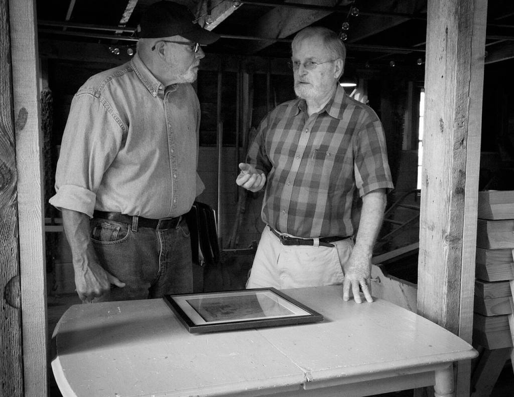 Terry Donnelly Photo
Hal Green and Bruce Haulman at the Paige/Green, Triplebrook Farm Barn, the oldest barn on Vashon. They are discussing the 2007 restoration Molly and Hal Green oversaw using dimensional fir lumber cut to match the original timbers, and the hand-cut steel nails they had made to match the original nails.