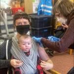 (Marijke van Heeswijk Photo) It Has Been a Long Pandemic: Zoe Burkland got her vaccination months ago when she was pregnant with Hazel. Now, heres Zoe getting her booster shot and she brought 6-month-old Hazel along. I encourage everyone to get vaccinated and get their booster shots. Thats especially true for pregnant people, Zoe said. Protecting our babies is so important, and getting a COVID vaccine during pregnancy is the best way to keep them safe, now and once theyre born. Also the mother of a 3-year-old who cannot yet receive a shot, Zoe said, Please vaccinate your big kids, too! After all, vaccinating kids is the missing piece to substantially lower transmission and getting closer to normal for everyone. Nurse Cece Reoux does the vaccination honors.