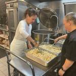 Lisa Cyra (left) and Meghen Morton (right), at work in the school districts main kitchen to prep meals for a day (Peter Woodbrook Photo).