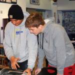 McMurray Middle School seventh-graders Luis Nunez Hernandez (left) and Jack Parker check out a book after a lesson on the Dewey Decimal System (Photo courtesy of PIE).