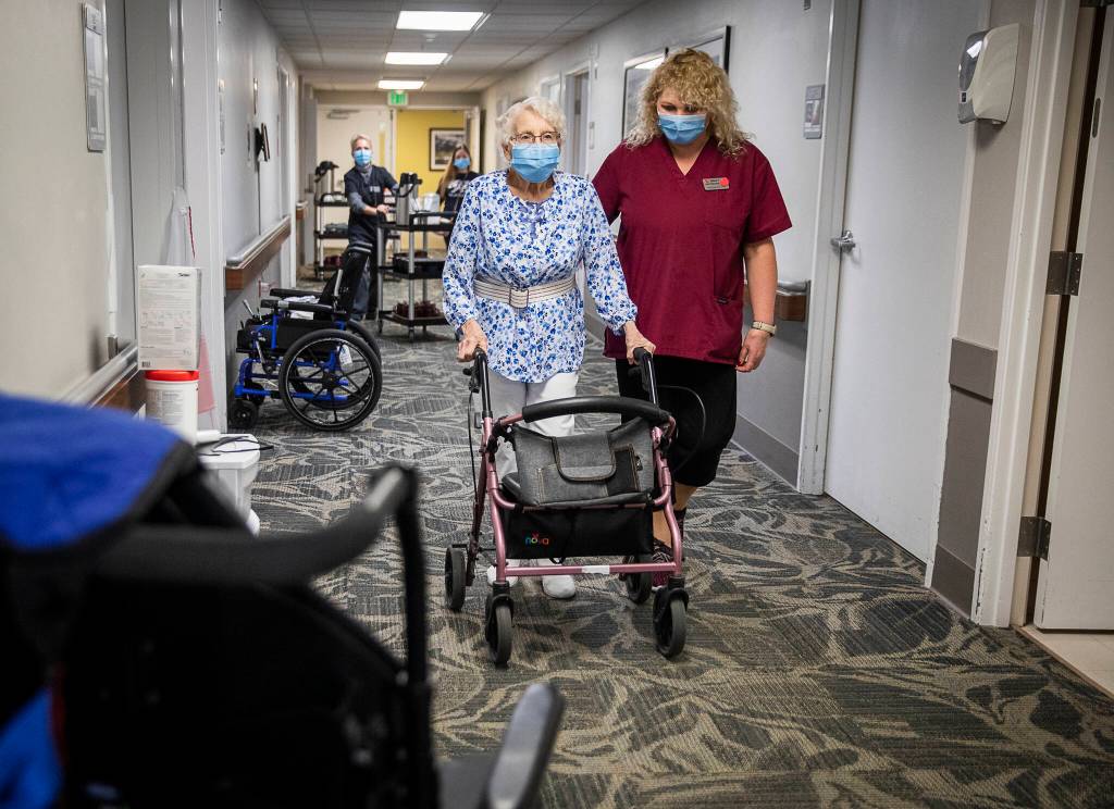 Olivia Vanni / The Herald
CNA Nina Prigodich, goes through restorative exercises with long term care patient Betty Long, 86, at View Ridge Care Center in Everett on Friday.