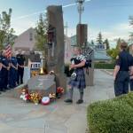 Fire district members and bagpiper Ella Yarkin, on Sept. 11 (Kate Davidson Photo).