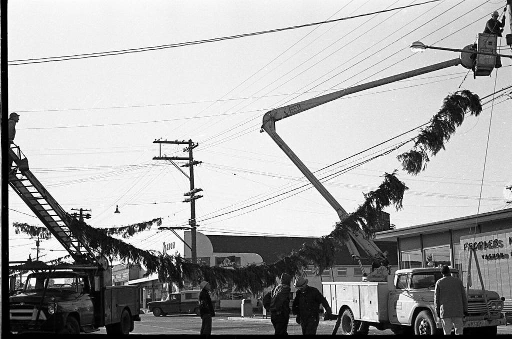 From 1963: Crews string up the lighted garlands that criss-crossed Vashon Highway before the candy canes were purchased in 1971. Photo courtesy Vashon Heritage Museum