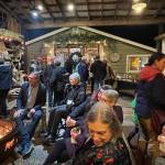 Longtime local artists Brian Fisher and Christine Beck (seated, center of photo) held court around a fire pit at Waterworks Studio during a preview party for the Vashon Island Studio Art Tour (Adrienne Edmonson Photo).