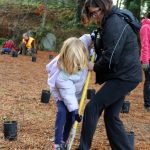 Violette Godinez, 6, and her mom, King County Parks Department spokesperson Andre Godinez, work together to dig room for a new plant uphill from the new Dockton Park Playground. Alex Bruell photo