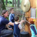 TJ Moore instructs kids at Island Outdoor School to play at the music wall without hitting the instruments too hard. One of the themes of outdoor schools is, instead of just having toys around it, you create stations for them to go and play with, Moore said. You can add to , you can change (Alex Bruell photo).