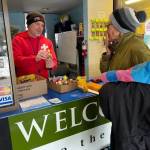 Derek Hinz presents a swimmer with a hand-crafted trollfy to recognize their achievements during the February Leap-Month Swim Challenge at the Vashon Pool (April Wilkinson Photo).