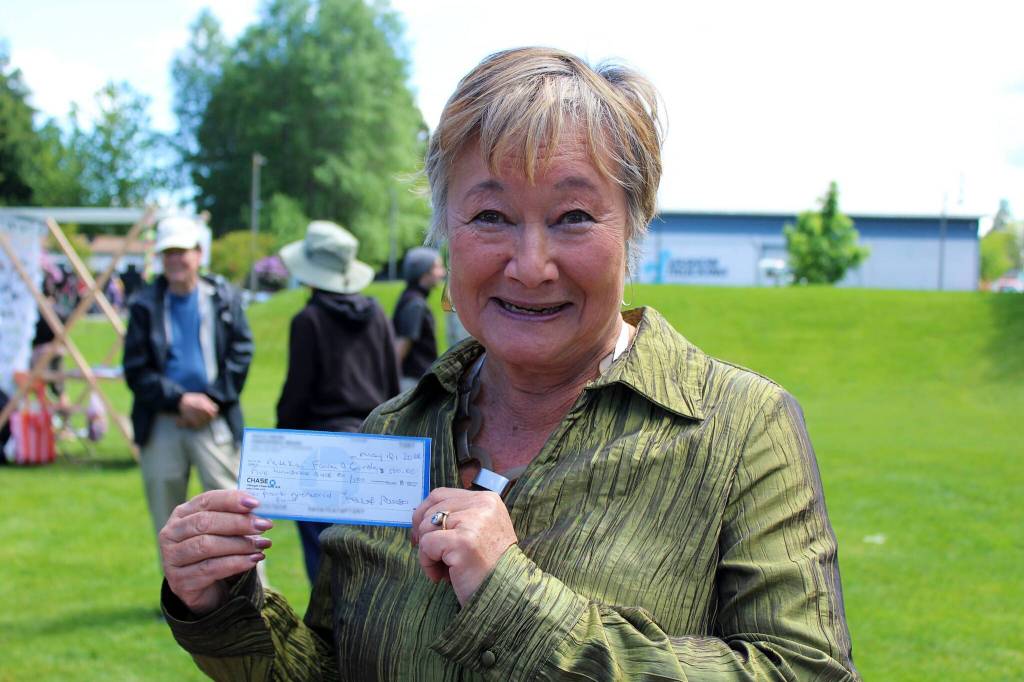 Alex Bruell photos
Rita Brogan holds up the first check received for the campaign to install a sculpture at Ober Park commemorating the Japanese Americans who were brought there in 1942 before their mass incarceration.