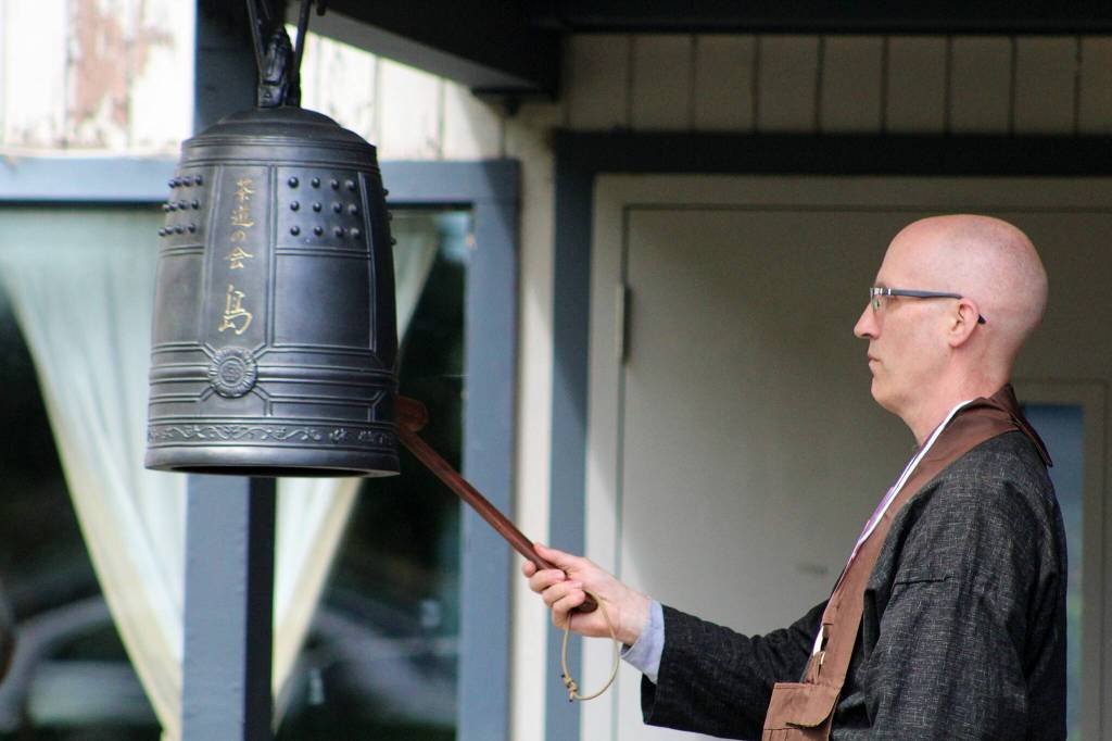 Koshin Cain, abbot of the Puget Sound Zen Center, rings a bell at Ober Park for each of the 30 Japanese American households exiled and imprisoned in 1942 during a blessing and ceremony.