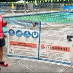 Megan Yeager (right), Vashon Park District lifeguard, swim instructor, and Vashon Seals Swim Team assistant coach, holds a banner of water safety tips with lifeguard colleague Michael Wish Wishkoski. At a bare minimum, every child should learn how to float, Yeager said. (Courtesy photo.)