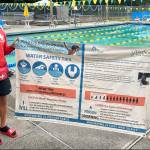 Megan Yeager (right), Vashon Park District lifeguard, swim instructor, and Vashon Seals Swim Team assistant coach, holds a banner of water safety tips with lifeguard colleague Michael Wish Wishkoski. At a bare minimum, every child should learn how to float, Yeager said. (Courtesy photo.)