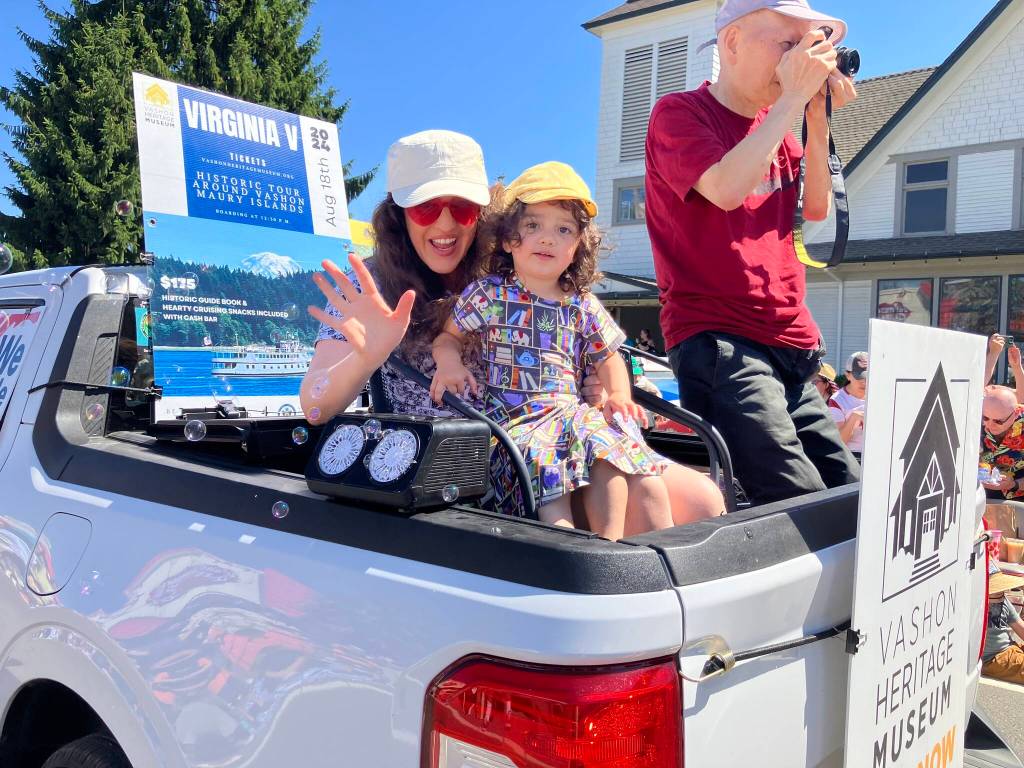 Along with her young daughter, Vashon Heritage Museums new executive director, Gretta Stimson soaked up the cheers of parade watchers. (Elizabeth Shepherd photo)