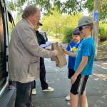 Savvy island kids grab a free lunch from Jim Marsh and Clara Atwell at Vashon Food Banks Picnics in the Parks truck, which offers free weekday lunches at Ober Park and Burton Area Recreation Center (BARC). (Elizabeth Shepherd photo)
