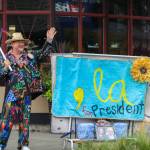 Islander Matt Beursken waves to drivers in Vashon town, sporting a colorful jacket and an American flag. (Aspen Anderson photo.)