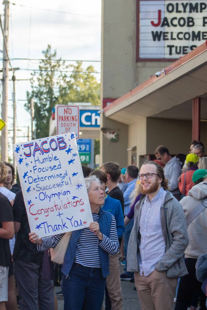 Crowd members hold signs welcoming Jacob Plihal home. (Alex Bruell photo)