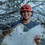 Vashon Nature Center Field Education Specialist Santiago Ramos-Torrescano smiles while holding a scapula (shoulder bone) from the gray whale. (Alex Bruell photo)
