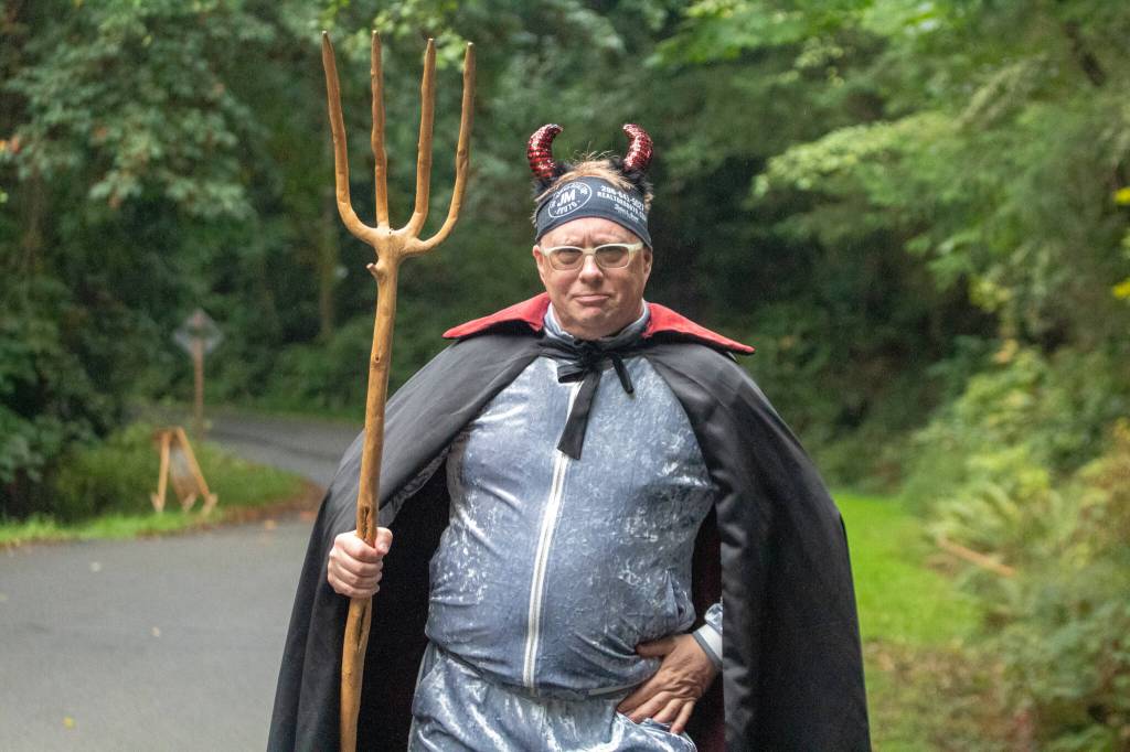 Jim Marsh is the Burma Road Devil, a character who directs traffic and playfully engages with Passport2Pain riders. This year, he used a wooden pitchfork to push riders along. (Alex Bruell photo)