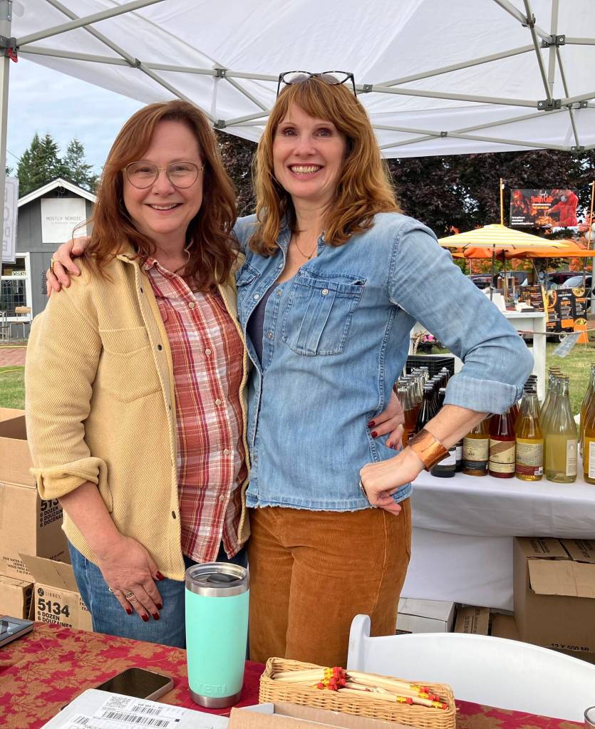 Cheryl Lubbert, of Nashi Orchards (left), and Jennifer Potter prepare for the day at Cider Fest. (Elizabeth Shepherd photo)