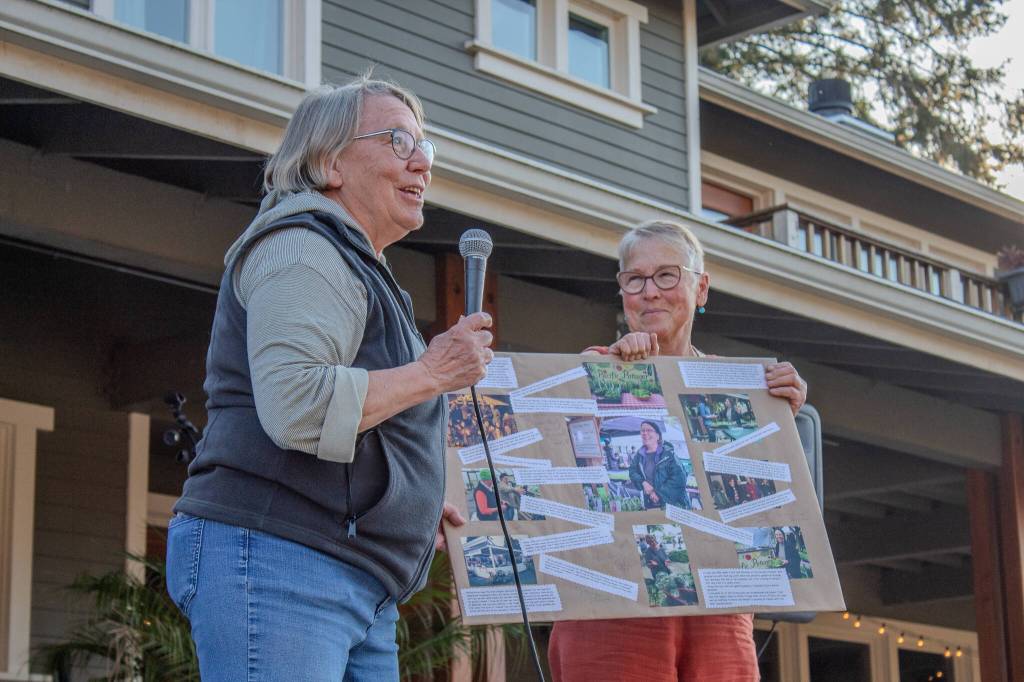 Michelle Crawford (left) is presented with a collage for her work by Karen Biondo, who co-leads VIGAs Food Access Partnership and who runs La Biondo Farm and Kitchen. (Alex Bruell photo)