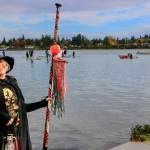 A witch pauses on shore, her paddle in hand and hat tilted just right, before joining the Halloween paddle on the waters. (Aspen Anderson photo)