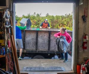 Alex Bruell photo
From left to right: Granny's Executive Director Brian Vescovi, employee Matt Voisin and assistant manager  Shelley Whannell toss trash into a dump truck the morning of Friday, Sept. 27. A load that size is taken to the dump "probably once a month," employees said.