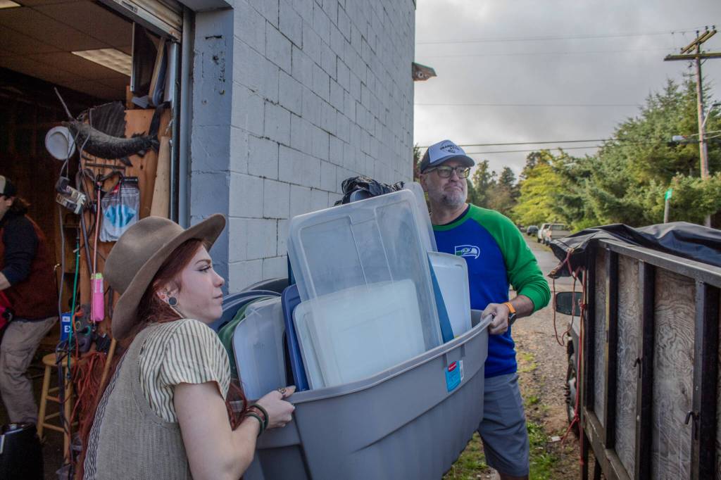 Brian Vescovi (right) and employee Thalia Goering carry trash to Grannys dump truck. (Alex Bruell photo)