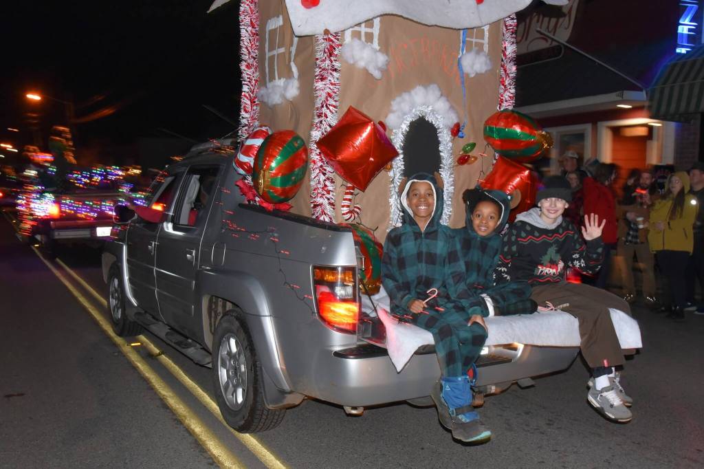 Kids smile for the camera while riding down Vashon Highway SW during the 2023 WinterFest parade. (Jim Diers photo)